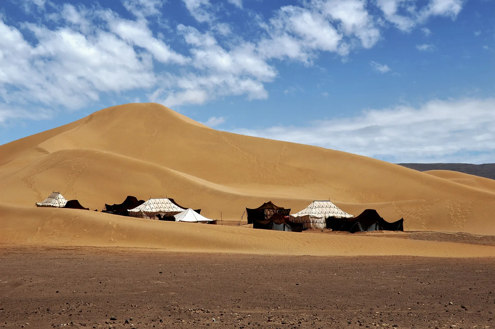 Nomadic tents standing among the dunes at M'Hamid El Ghizlane
