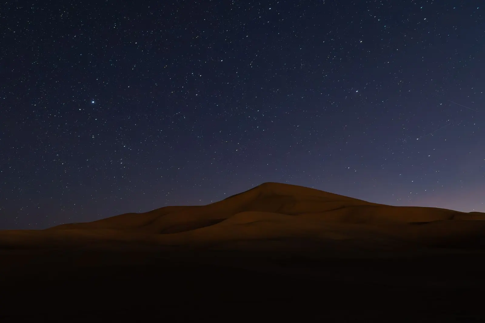 Sahara dunes under a starry night sky